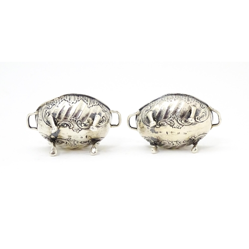 279 - A pair of Continental .930 silver salts with  engraved decoration and twin handles raised on four fe... 