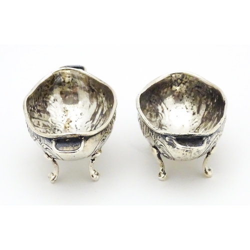 279 - A pair of Continental .930 silver salts with  engraved decoration and twin handles raised on four fe... 