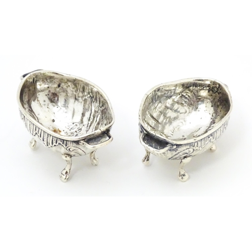 279 - A pair of Continental .930 silver salts with  engraved decoration and twin handles raised on four fe... 