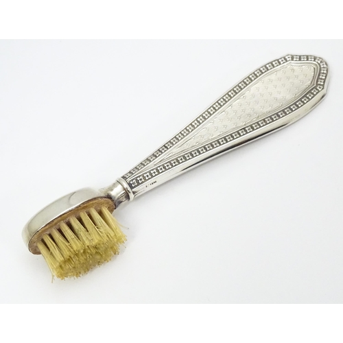 304 - A silver handled moustache brush with engine turned decoration.  Hallmarked Birmingham 1927