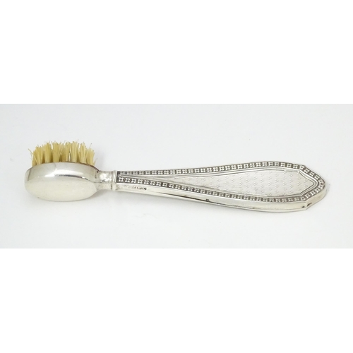 304 - A silver handled moustache brush with engine turned decoration.  Hallmarked Birmingham 1927