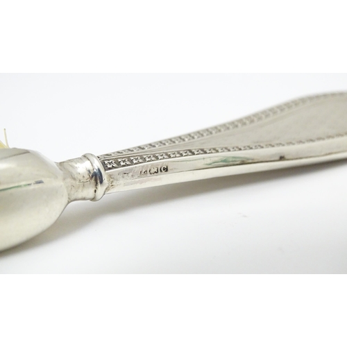 304 - A silver handled moustache brush with engine turned decoration.  Hallmarked Birmingham 1927