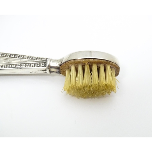 304 - A silver handled moustache brush with engine turned decoration.  Hallmarked Birmingham 1927