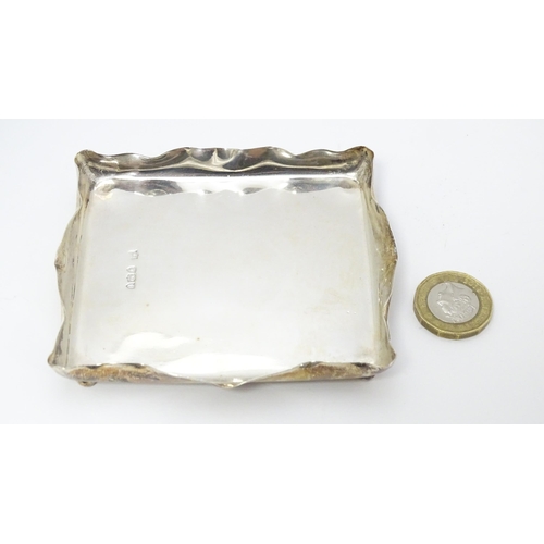 310 - A Victorian silver pin dish of rectangular form raised on four ball feet. Hallmarked London 1895 mak... 