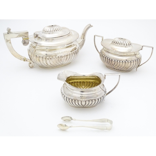 322 - A three piece silver tea set comprising teapot, milk jug and  lidded sugar bowl, together with sugar... 