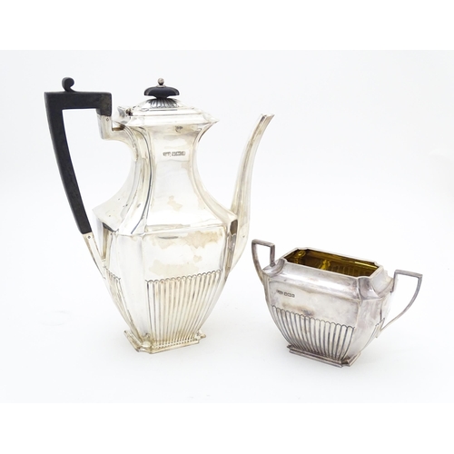 323 - A silver coffee / hot water  pot hallmarked Sheffield 1910 together with a twin handled sugar hallma... 