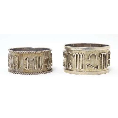 334 - Two Continental silver napkin rings  both decorated with astrological symbols. One with rope twist s... 