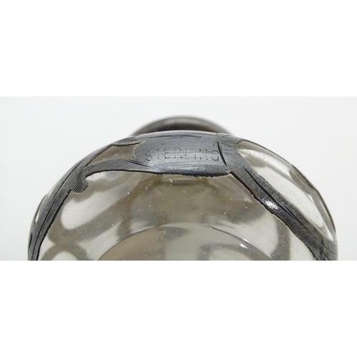 352 - A glass scent / perfume bottle with silver overlay. Marked Sterling. Approx 2 1/2