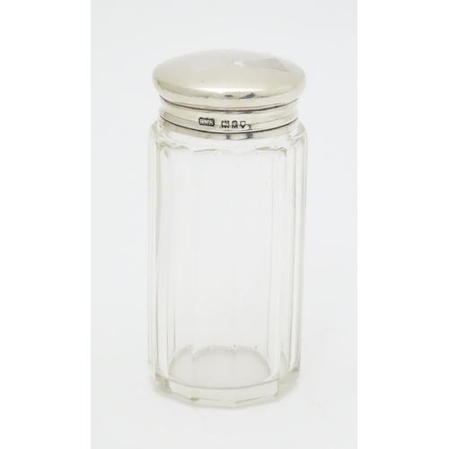 397 - A glass toilet / dressing table jar with silver lid hallmarked London 1912 maker Loebl & Co. 3 1/4