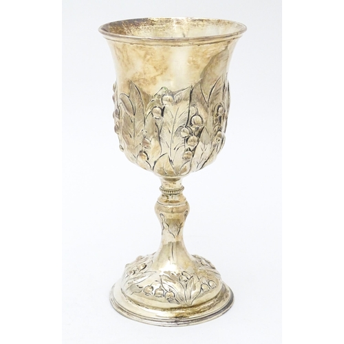 432 - A Victorian silver cup / chalice / goblet with repousse lily of the valley floral  decoration. Hallm... 