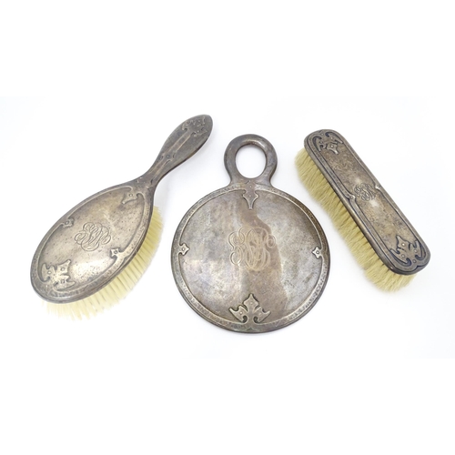 489 - Three American sterling silver backed items comprising two brushes and a hand mirror. Mirror approx.... 