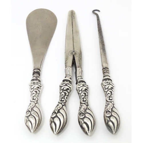 517 - Three silver handled items comprising shoe horn, button hook and glove stretches. Shoe horn approx. ... 