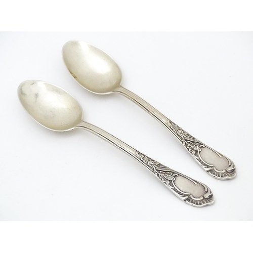 533 - Two Russian / Soviet silver teaspoons with foliate detail to handles, marked 875. Approx. 5 1/4