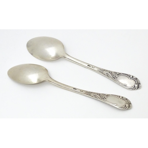 533 - Two Russian / Soviet silver teaspoons with foliate detail to handles, marked 875. Approx. 5 1/4