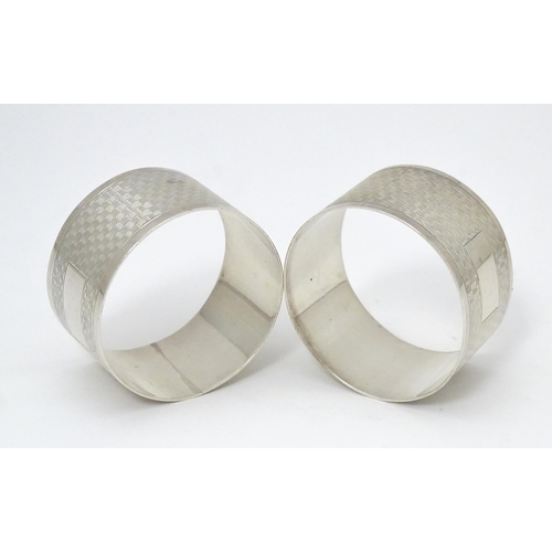 570 - A pair of silver napkin rings with engine turned decoration, hallmarked Birmingham 1957, maker Willi... 