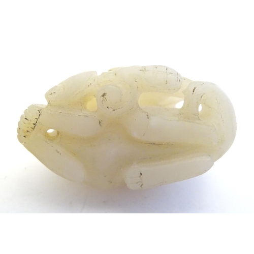 1188 - An Oriental jade carving modelled as a stylised cat amid scrolling foliage. Approx. 1