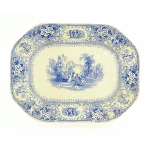 169 - A blue and white transfer printed meat plate depicting knights before a castle, bordered by vignette... 