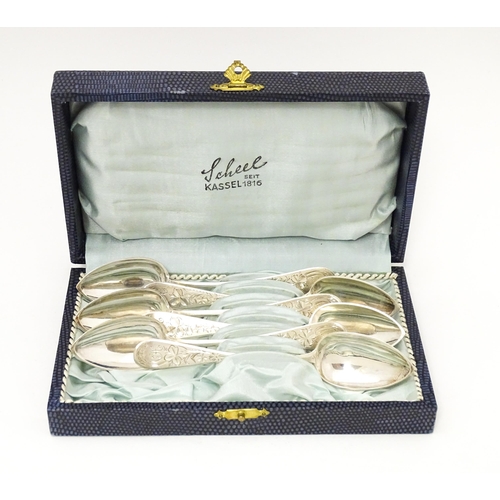 609 - A set of six German .800 silver spoons with engraved foliate decoration to handles. the cased Marked... 