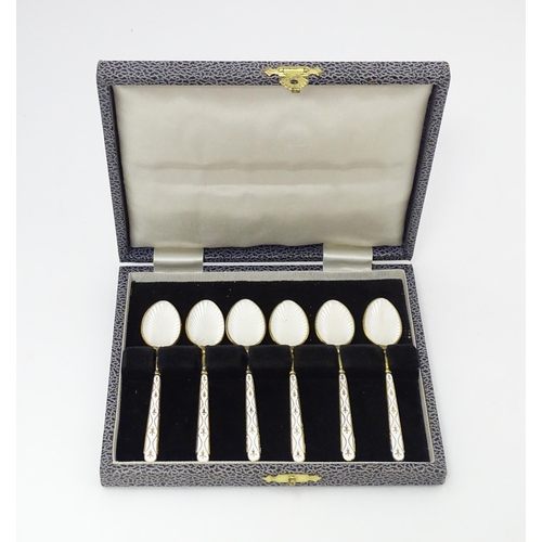 612 - A set of 6 silver gilt teapsoons with white guilloche enamel decoration to bowls and further enamel ... 