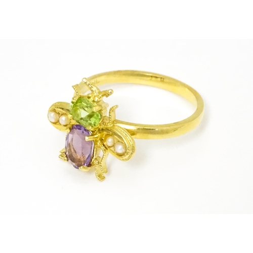 641 - A silver gilt ring with bee / winged insect decoration set with amethyst, pearl and peridot. Ring si... 