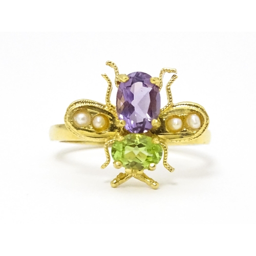 641 - A silver gilt ring with bee / winged insect decoration set with amethyst, pearl and peridot. Ring si... 