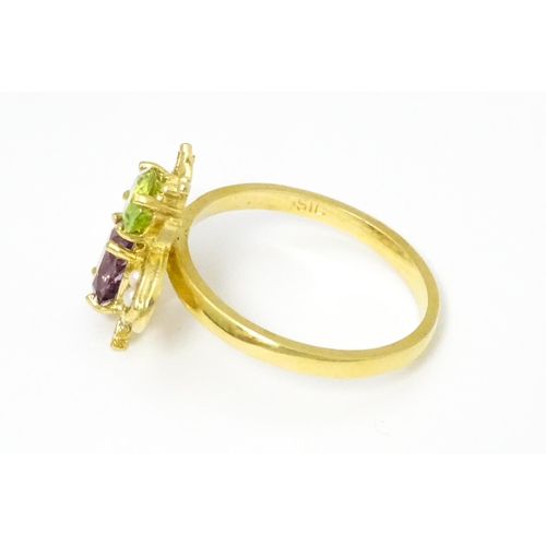 641 - A silver gilt ring with bee / winged insect decoration set with amethyst, pearl and peridot. Ring si... 