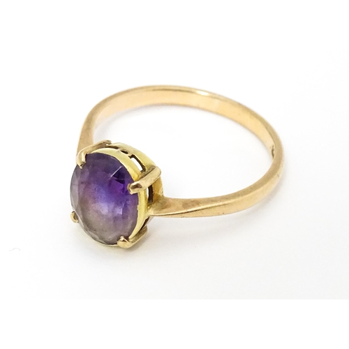 646 - A 9ct gold ring set with oval amethyst in a claw setting. Ring size approx. P 1/2