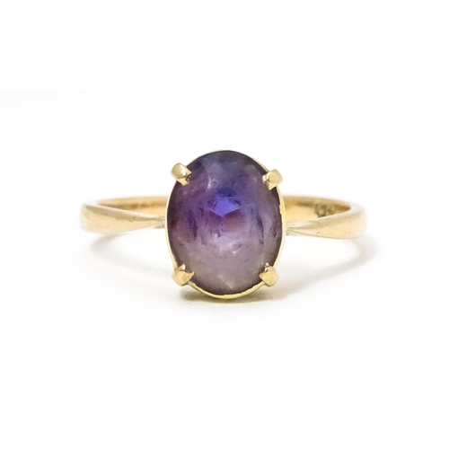 646 - A 9ct gold ring set with oval amethyst in a claw setting. Ring size approx. P 1/2