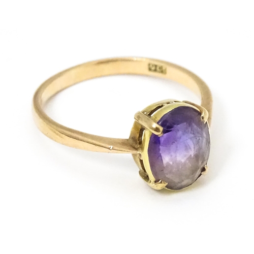 646 - A 9ct gold ring set with oval amethyst in a claw setting. Ring size approx. P 1/2