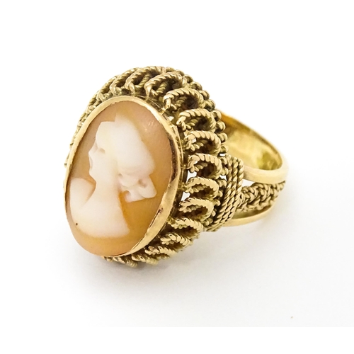 647 - A Continental gold ring set with central shell carved cameo with a filigree mount. Ring size approx.... 