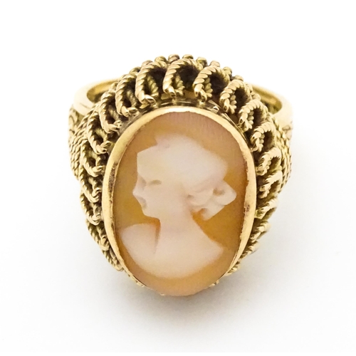 647 - A Continental gold ring set with central shell carved cameo with a filigree mount. Ring size approx.... 