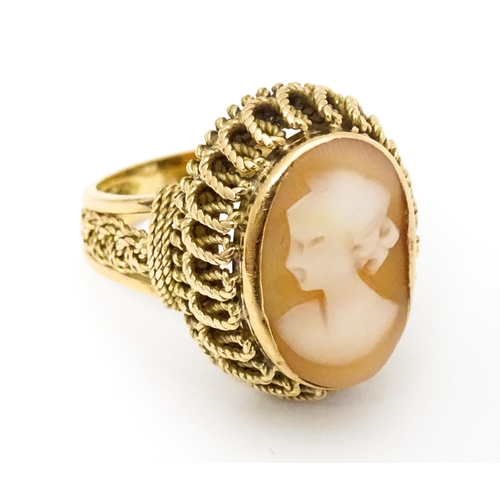 647 - A Continental gold ring set with central shell carved cameo with a filigree mount. Ring size approx.... 