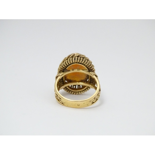 647 - A Continental gold ring set with central shell carved cameo with a filigree mount. Ring size approx.... 