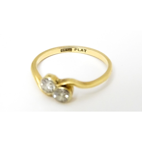 648 - An 18ct gold ring with two platinum set round cut diamonds. Ring size approx. M