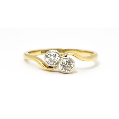 648 - An 18ct gold ring with two platinum set round cut diamonds. Ring size approx. M