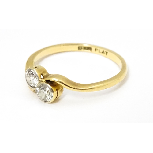 648 - An 18ct gold ring with two platinum set round cut diamonds. Ring size approx. M