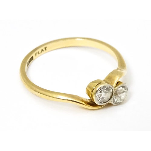 648 - An 18ct gold ring with two platinum set round cut diamonds. Ring size approx. M