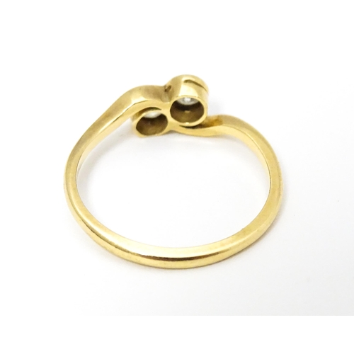 648 - An 18ct gold ring with two platinum set round cut diamonds. Ring size approx. M