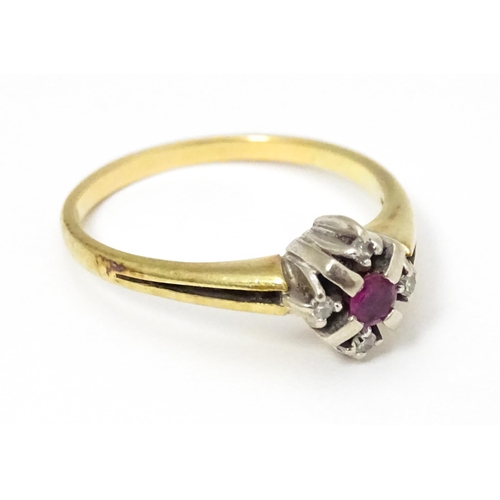 654 - A 14ct gold ring set with central ruby bordered by four diamonds. Ring size approx. Q