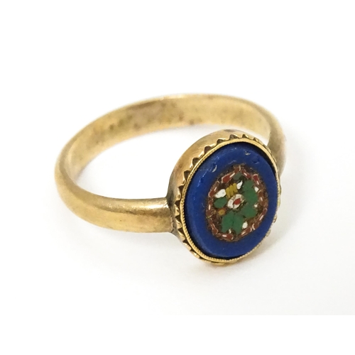 657 - Grand Tour Jewellery : A yellow metal ring with micro mosaic decoration. Ring size approx. H