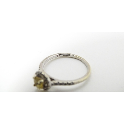 660 - A 9ct white gold ring set with central citrine coloured stone bordered by diamonds and with further ... 