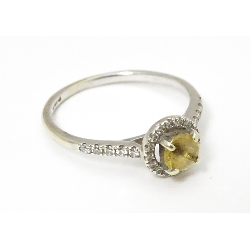 660 - A 9ct white gold ring set with central citrine coloured stone bordered by diamonds and with further ... 