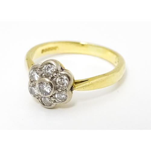 661 - An 18ct  gold ring set with 7 diamonds in a daisy setting. Ring size approx. H