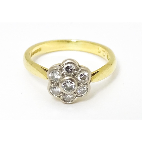 661 - An 18ct  gold ring set with 7 diamonds in a daisy setting. Ring size approx. H