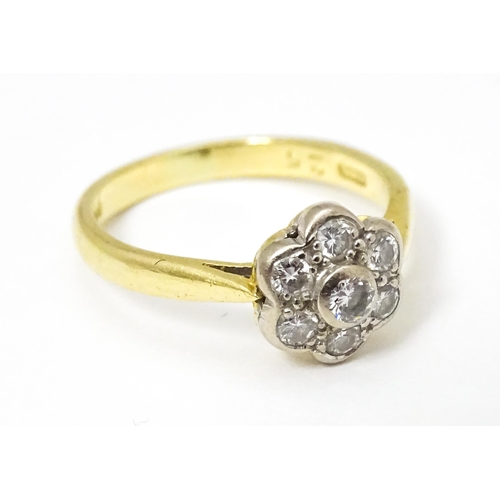 661 - An 18ct  gold ring set with 7 diamonds in a daisy setting. Ring size approx. H