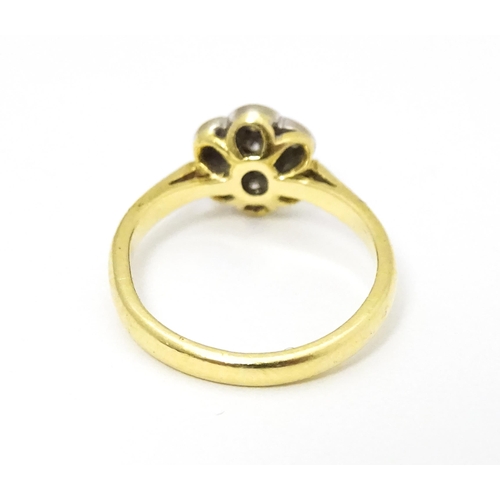 661 - An 18ct  gold ring set with 7 diamonds in a daisy setting. Ring size approx. H