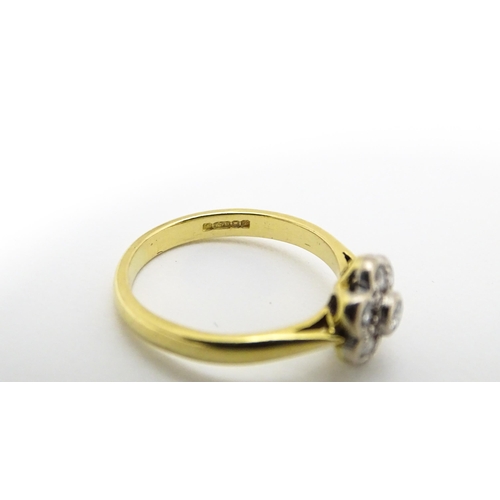 661 - An 18ct  gold ring set with 7 diamonds in a daisy setting. Ring size approx. H