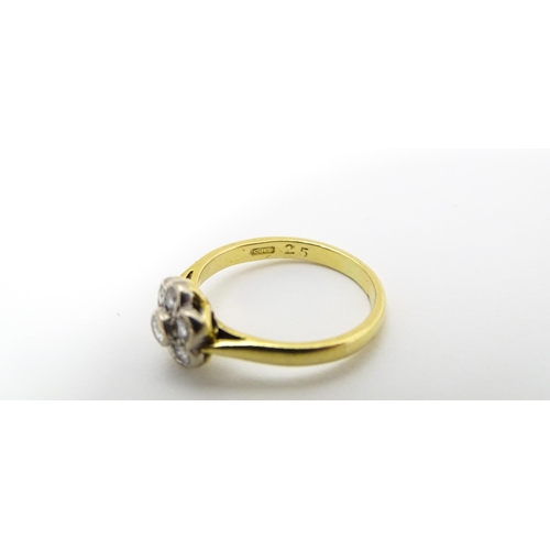 661 - An 18ct  gold ring set with 7 diamonds in a daisy setting. Ring size approx. H