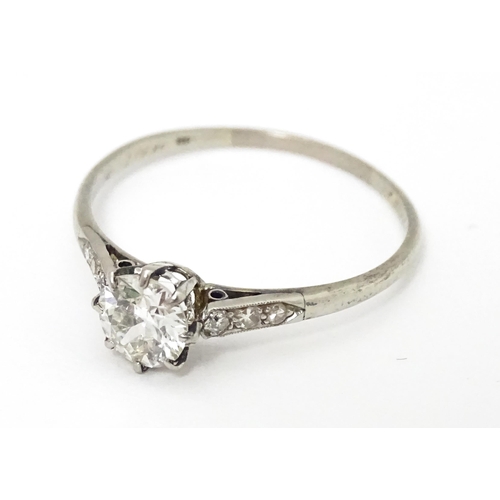 662 - A 18ct white gold ring set with diamond solitaire ring flanked by 3 diamonds to the shoulders. Ring ... 