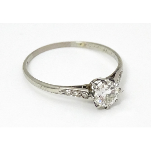 662 - A 18ct white gold ring set with diamond solitaire ring flanked by 3 diamonds to the shoulders. Ring ... 